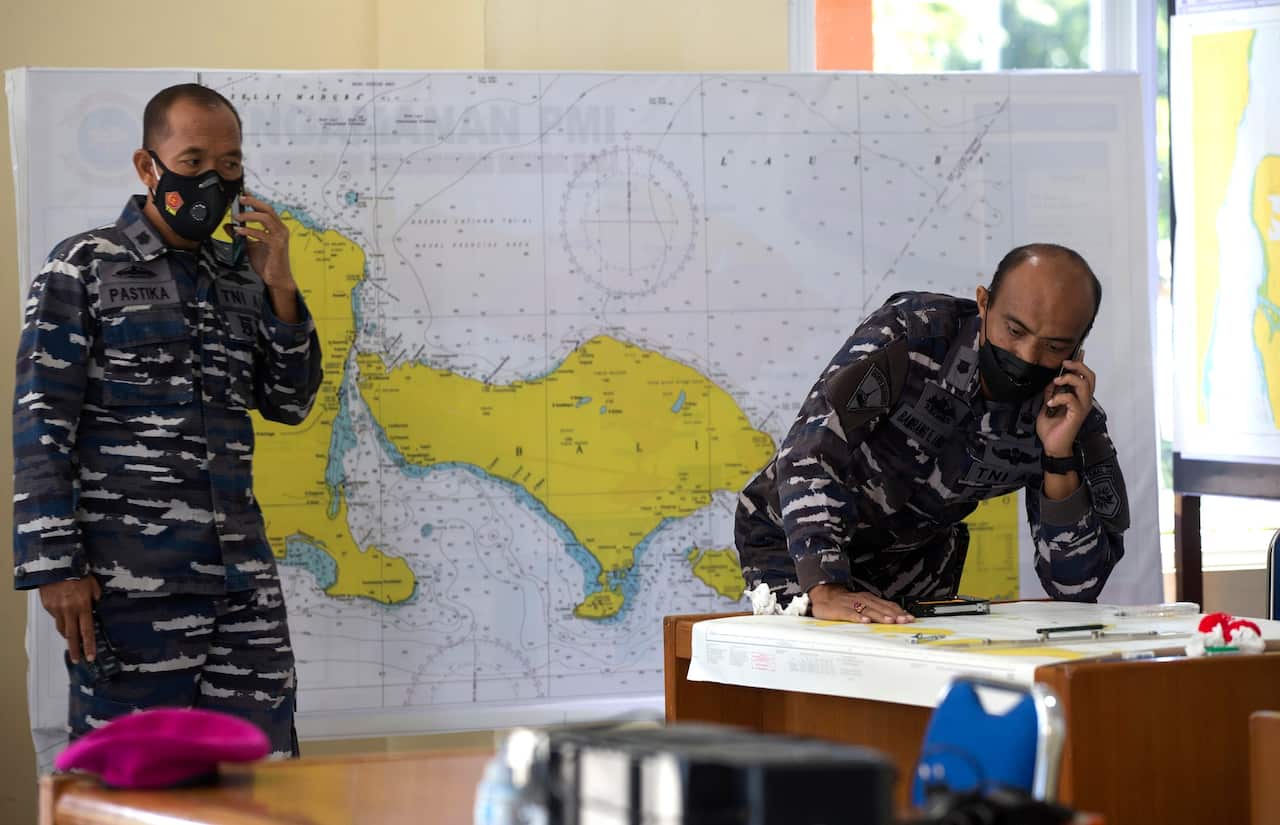 Indonesian military officials look at a map of the location where the Indonesian Navy submarine KRI Nanggala went missing.