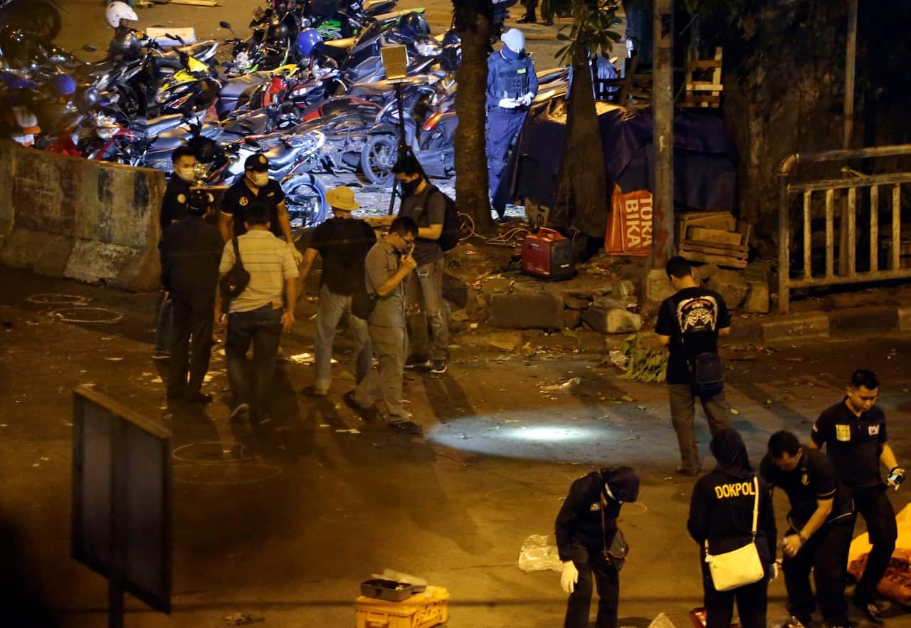 Body bags are lined up as police officers conduct their investigation near the site in Jakarta (AAP)