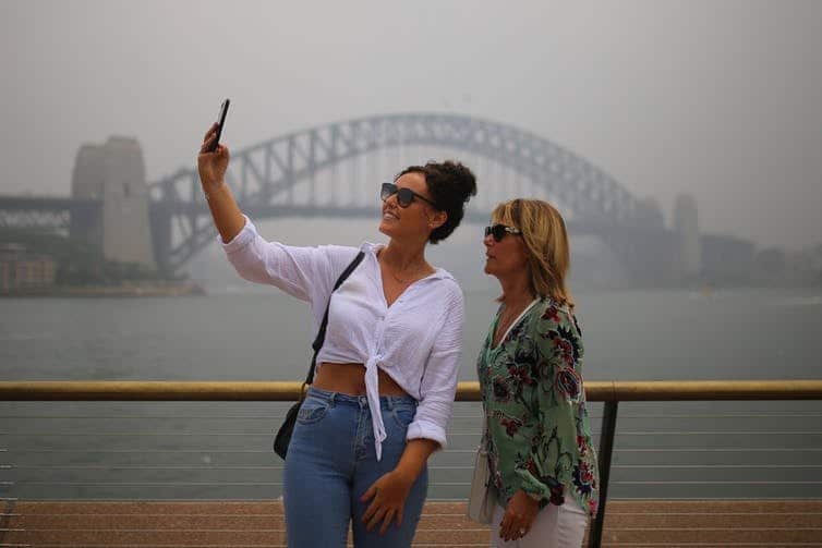 Tourists take selfies against a smoke-filled Sydney Harbour last month. Air quality in Sydney is set to plunge once again. 