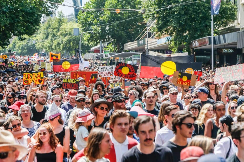 A general view of protestors marching holding placards and shouting chants during a protest by Aboriginal rights activist on Australia Day in Melbourne.