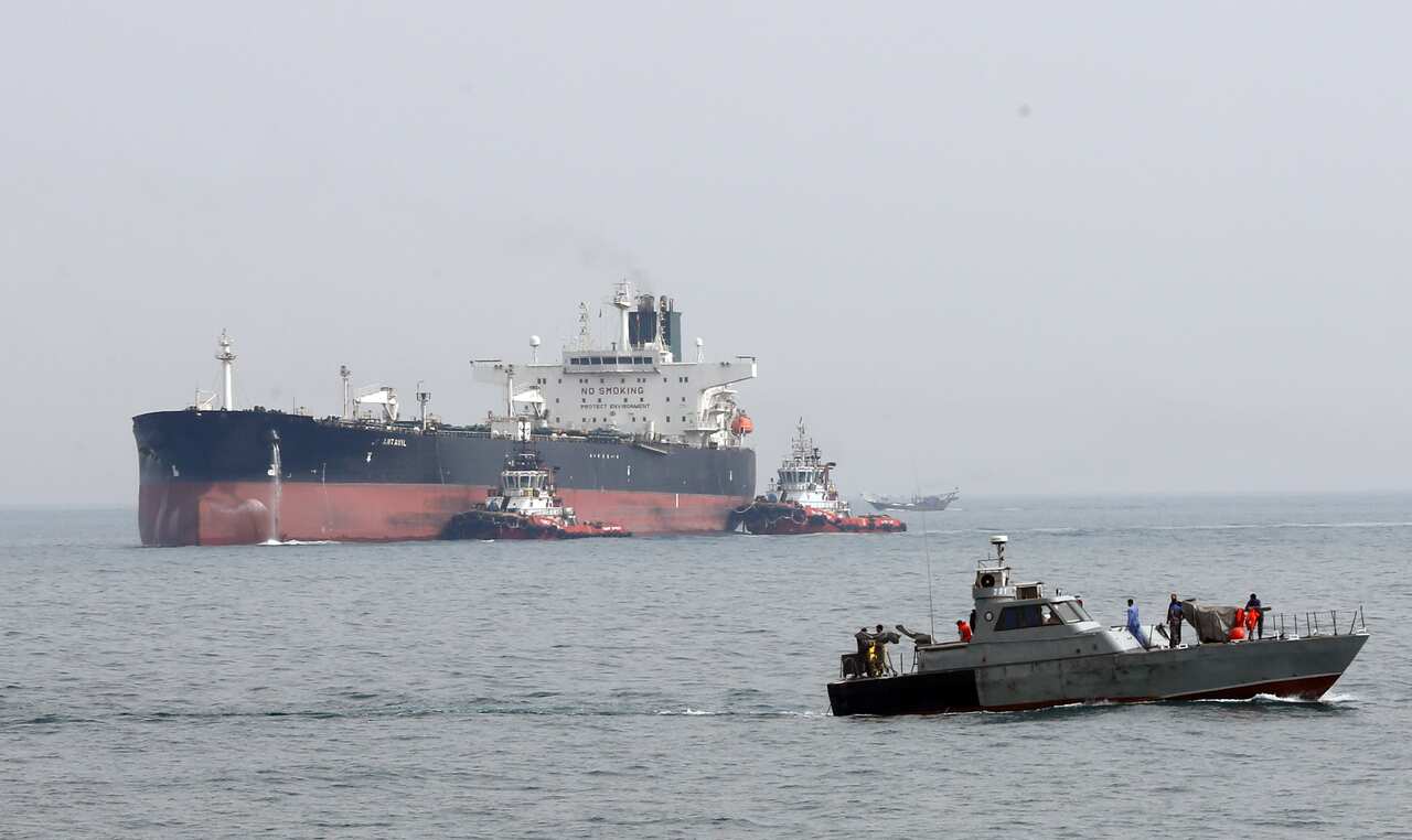 An Iranian military boat patrols next to the Artavil oil tanker, at the Kharg Island, in Persian Gulf, southern Iran.