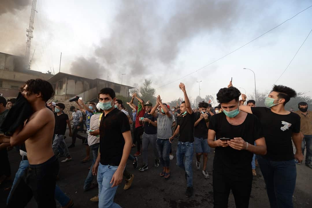 Iraqi protesters chant slogans outside the municipal buildings of Basra.