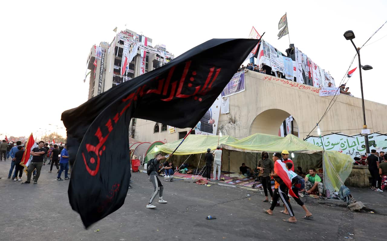 An Iraqi protester waves a religious banner during ongoing protests at Al Tahrir square in central Baghdad.