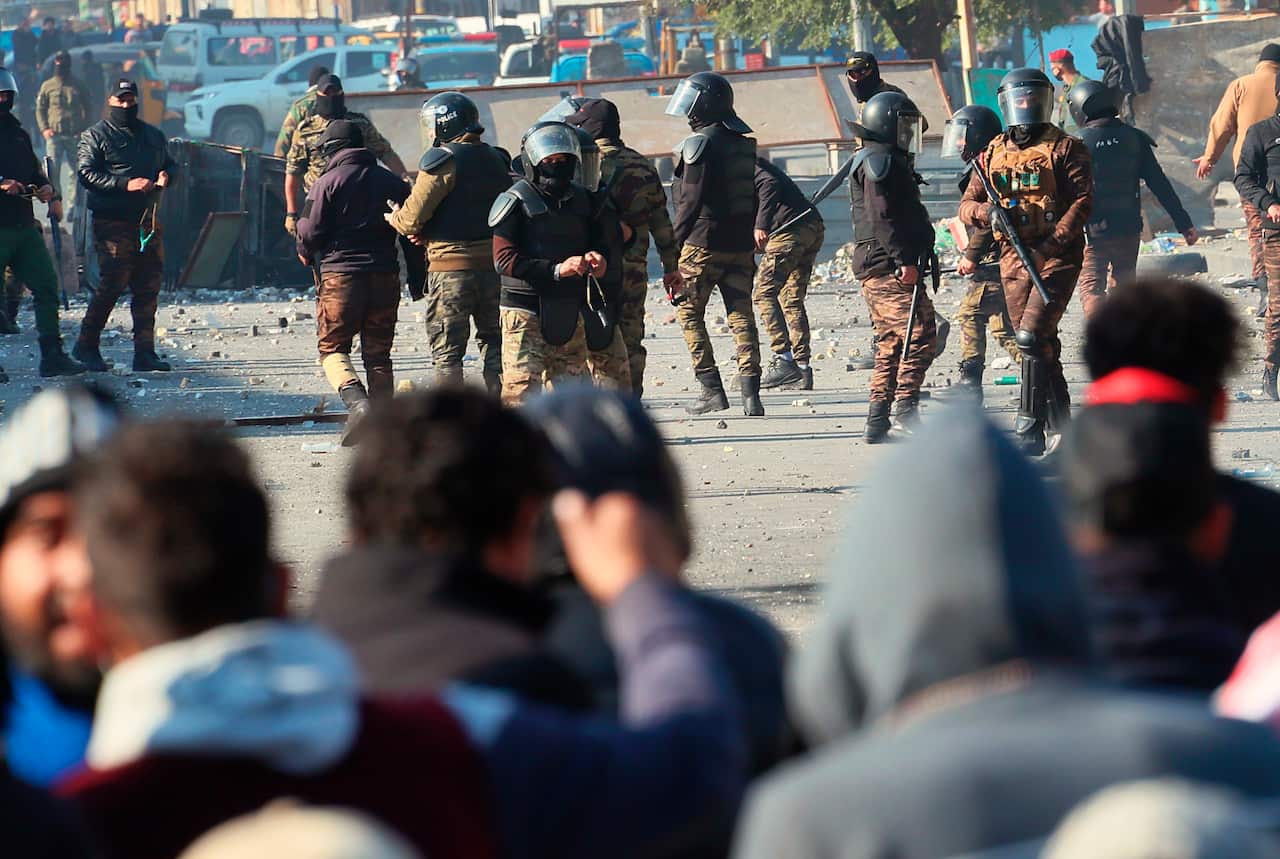 Security forces try to disperse anti-government protesters during clashes in Baghdad.