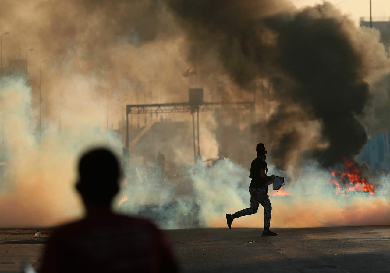 Anti-government protesters set fires and close a street during a demonstration in Baghdad.