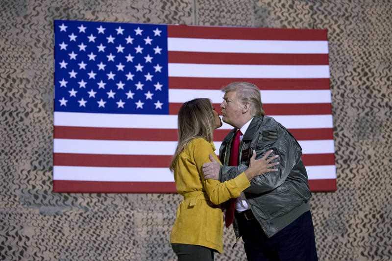 President Donald Trump kisses first lady Melania Trump during a hanger rally at Al Asad Air Base, Iraq.