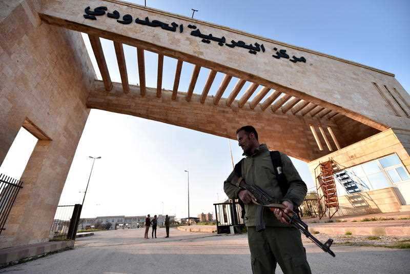 A member of US-backed Syrian Democratic Forces (SDF), stands guard at the Ya'arubiya border crossing with Iraq in northeastern Hasakah province, northern Syria.
