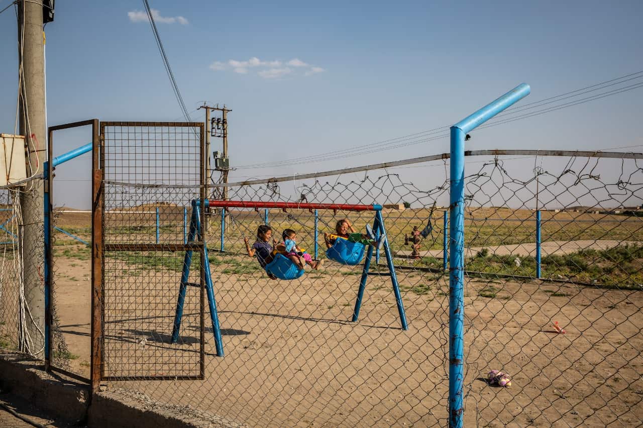 Youths play on swings at Roj Camp for the families of IS members in Kurdish-controlled northern Syria, June 23, 2018.