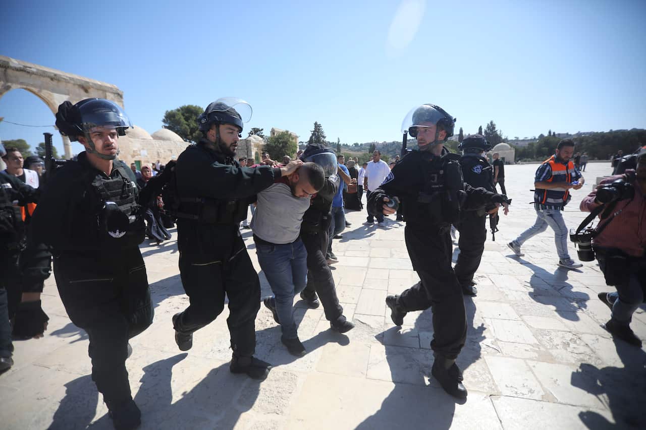 Police lead the arrested man from the scene. 