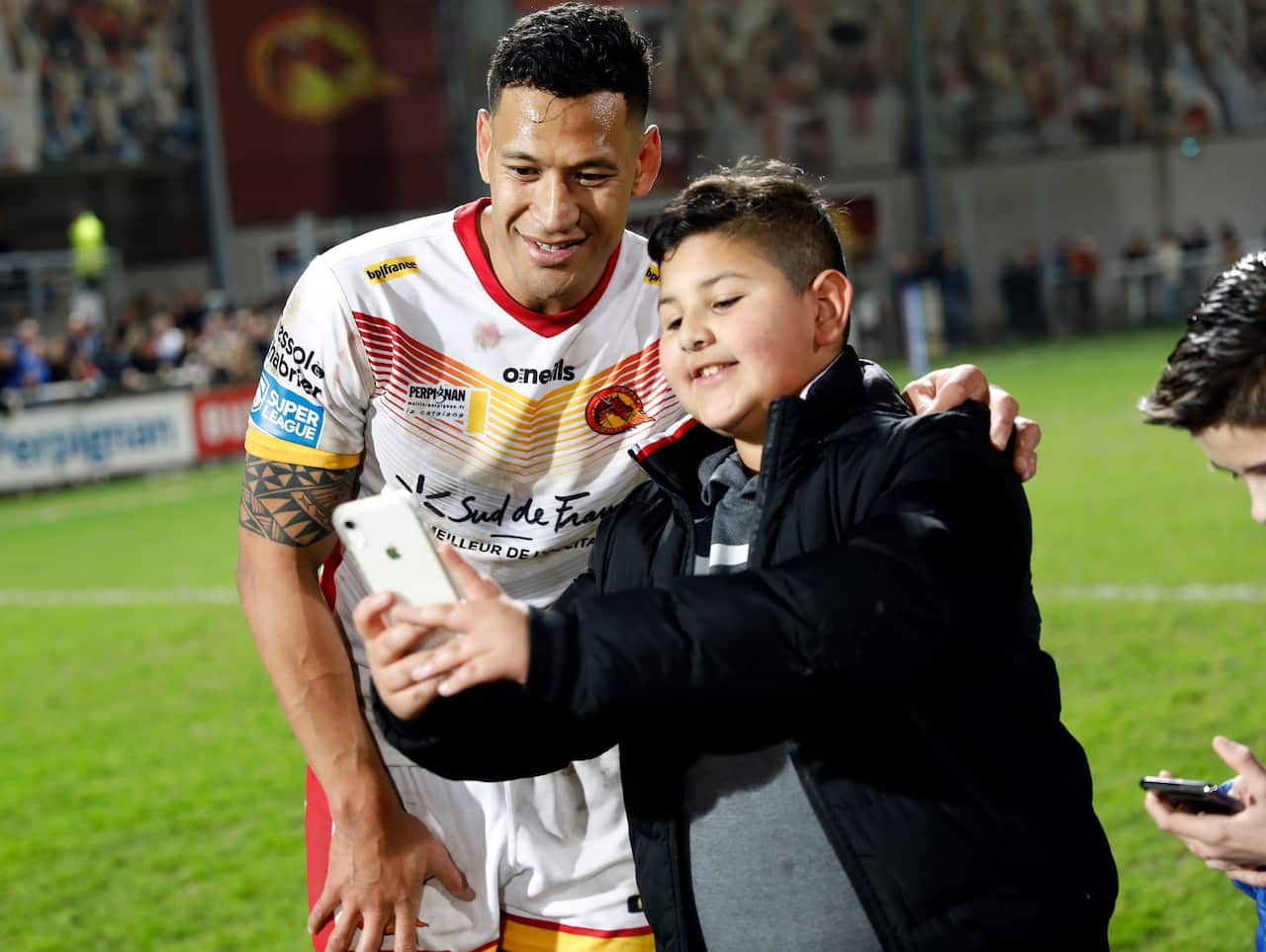 Israel Folau has his photo taken with a young fan after the Super League rugby match between Catalans Dragons and Castleford Tigers.