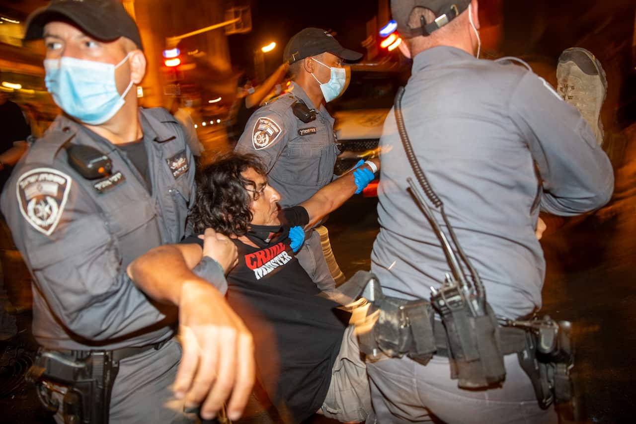 Israeli police officers carry away a demonstrator (AAP)
