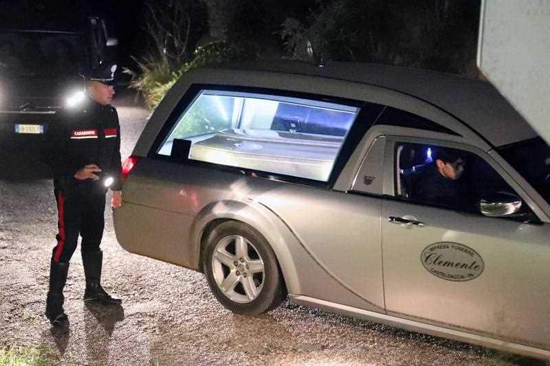 A Carabinieri (Italian paramilitary police) officer stands by a car carrying the coffin of one of the nine people killed in the flooding.
