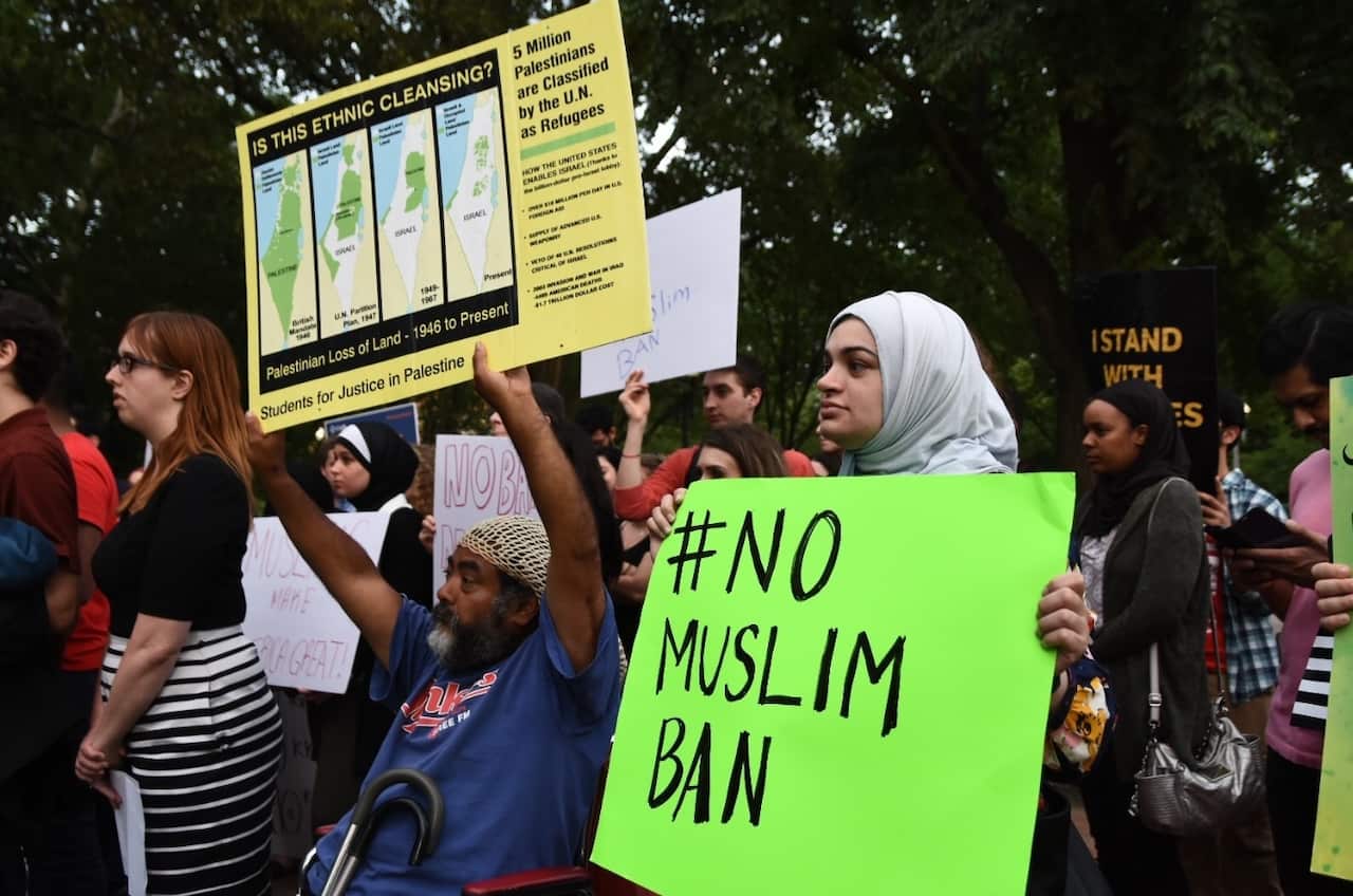 Demonstrators hold signs during Iftar, the traditional dinner ending the Ramadan fast, outside of the White House in Washington