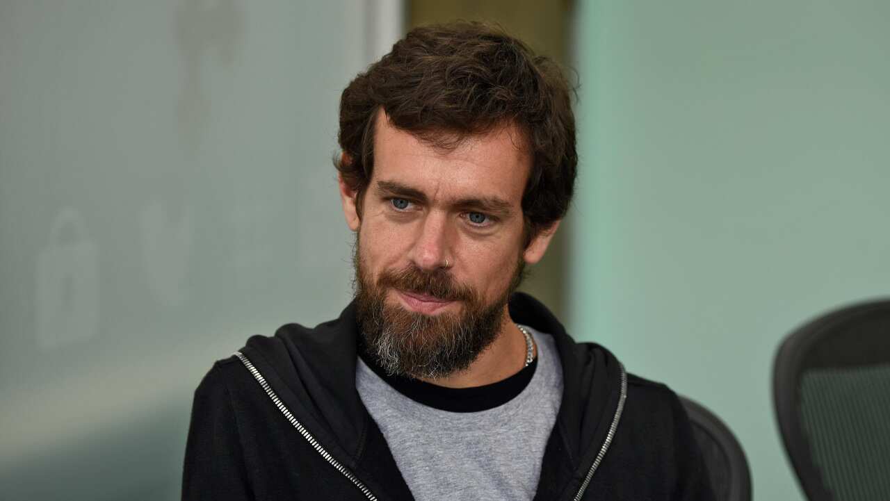 A man with brown hair and a beard in a hoodie. 