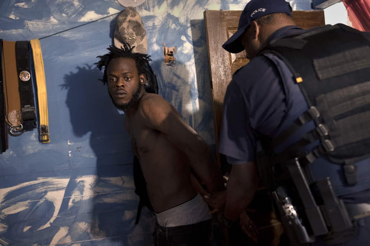 Police arrest a suspect on the streets of Kingston, Jamaica, an island nation suffering one of the highest homicide rates in the world