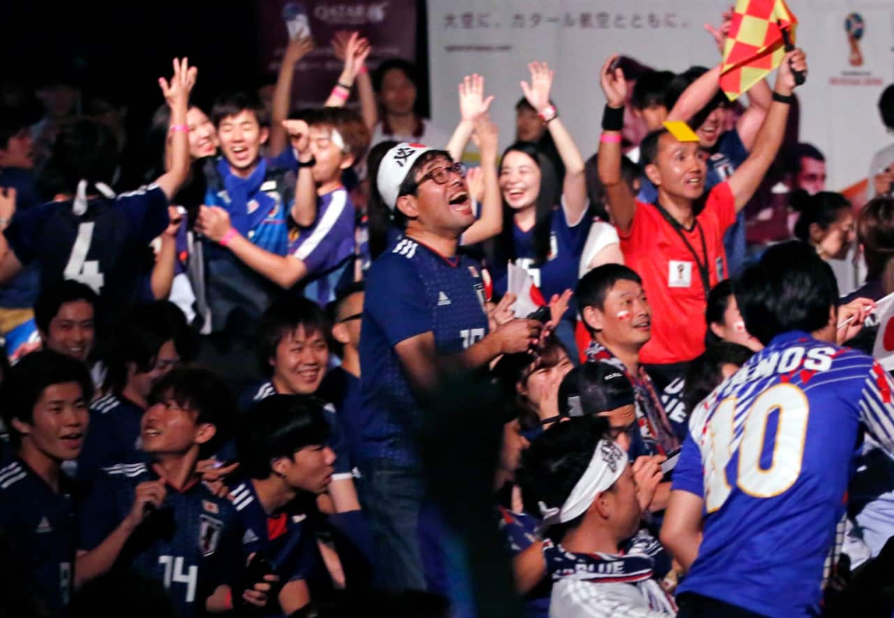 Japanese soccer fans celebrate at a public viewing venue in Tokyo, Thursday, June 28, 2018