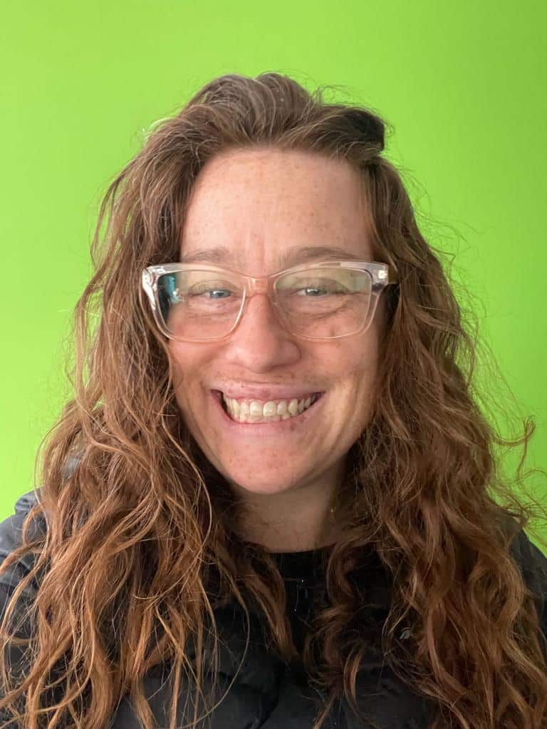 A woman wearing glasses and smiling