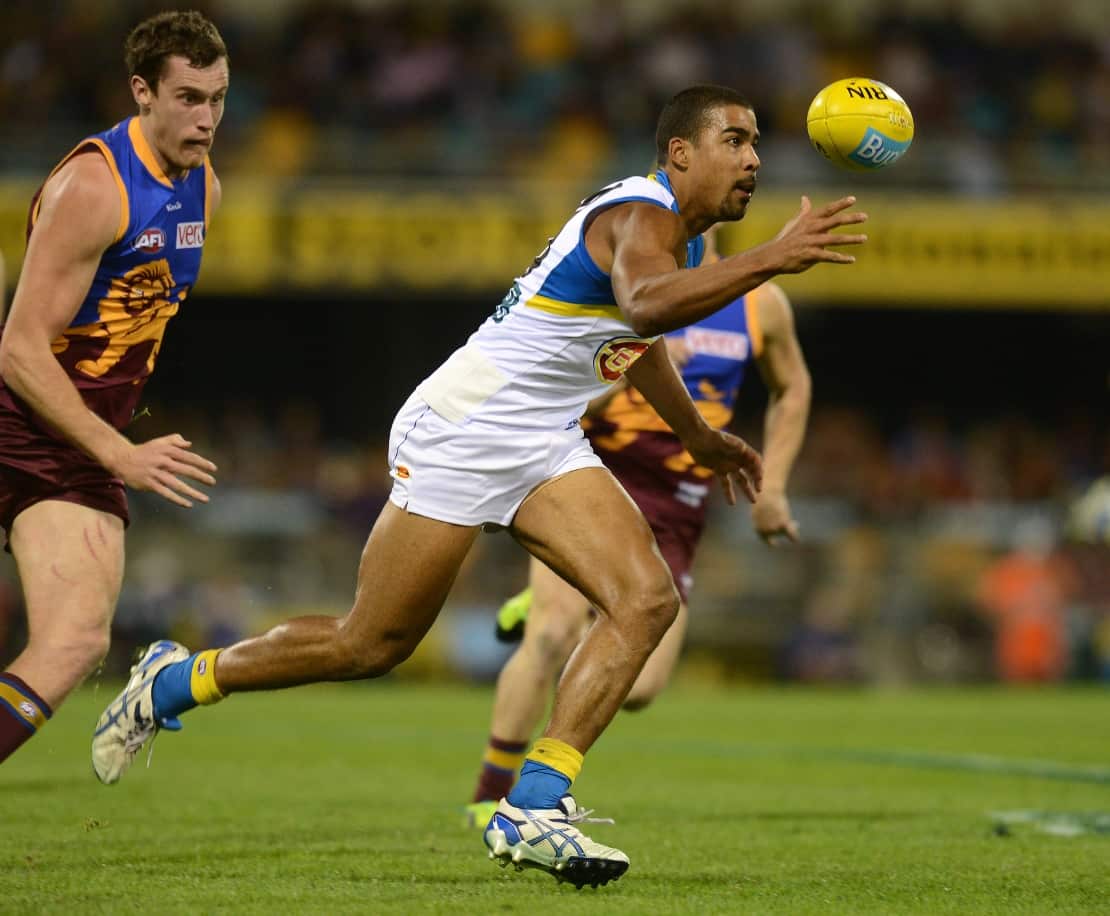 Suns player Joel Wilkinson (right) recovers the ball during the Round 15 AFL match between the Brisbane Lions in July 2013.