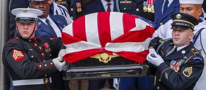 An honour guard carries Senator John McCain's body from the church.