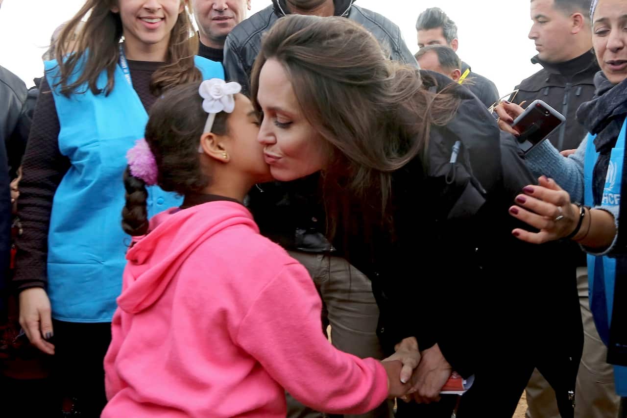 The U.N. refugee agency's special envoy, actress Angelina Jolie poses with Syrian child.