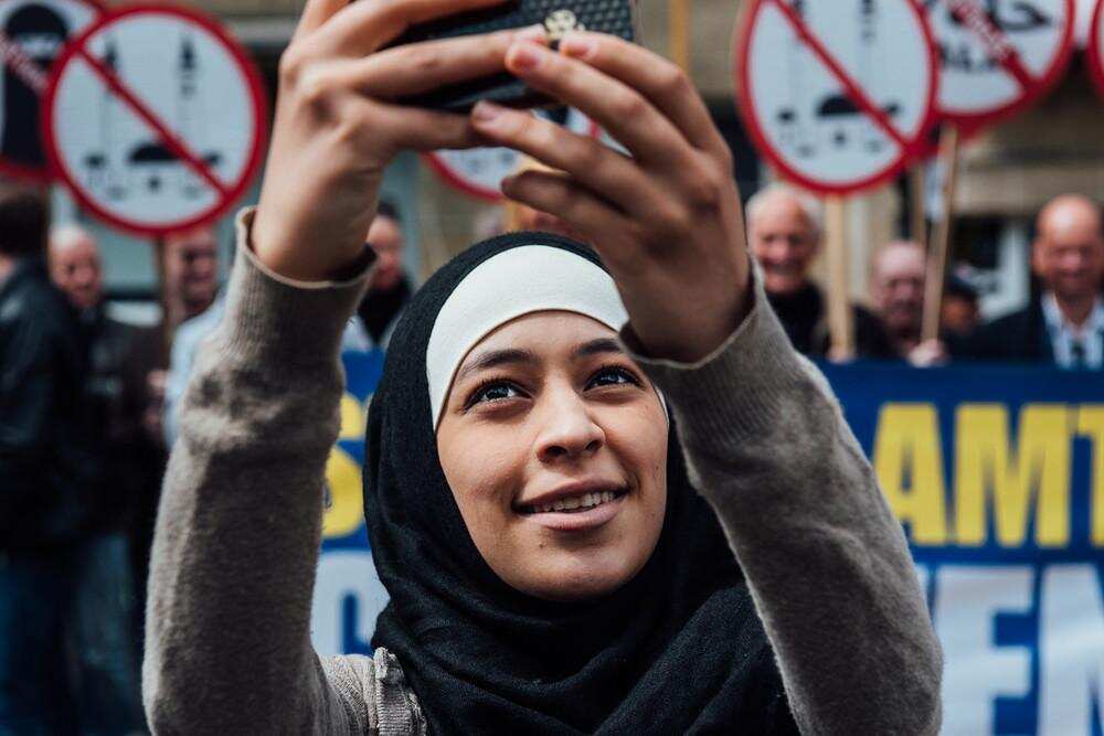 Credit Jürgen Augusteyns. Picture of Muslim woman Zakia Belkhiri taking selfies with anti-Islam group in Belgium.