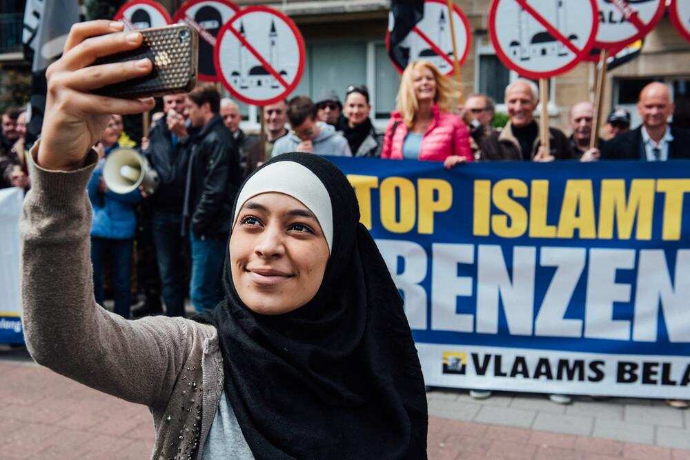 Credit Jürgen Augusteyns. Picture of Muslim woman Zakia Belkhiri taking selfies with anti-Islam group in Belgium.