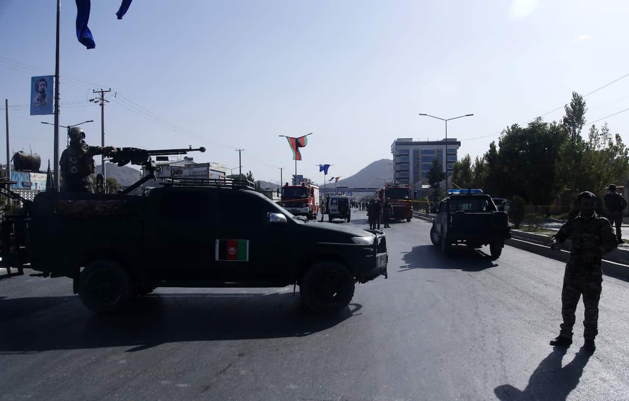 Afghan security officers inspect the scene of a suicide attack targeting convey of followers of Afghanistan national hero