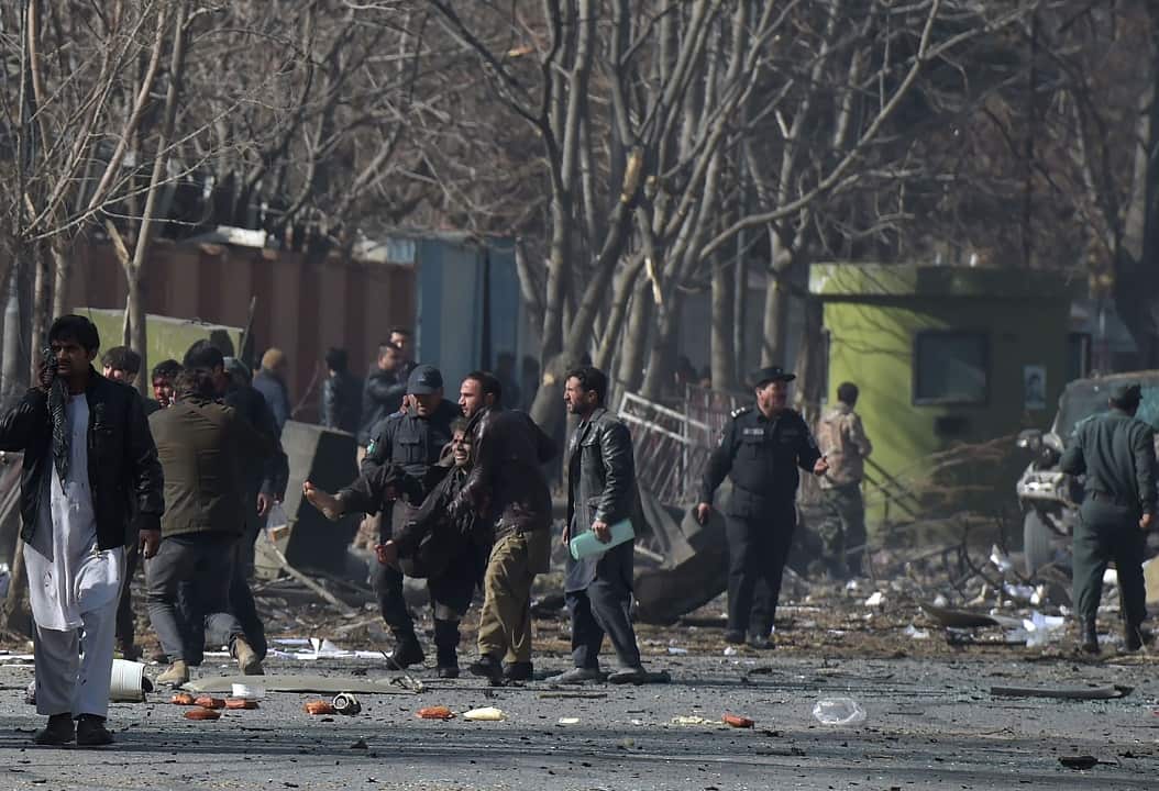 Afghan volunteers and policemen help the wounded.