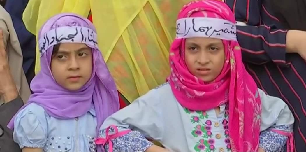 Young girls wearing headbands reading "Kashmir is ours".