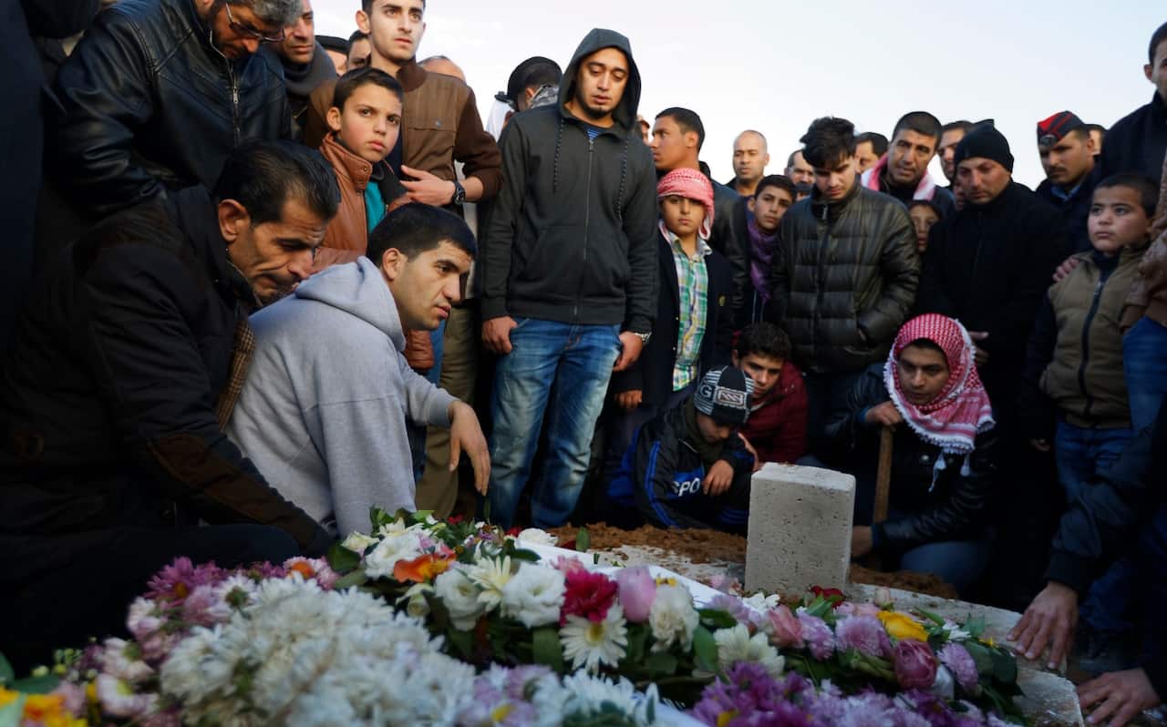 Members of the Jordanian Gendarmerie, other police, and residents mourn the death of Lieutenant Colonel Saed al-Maaytah, as his body is laid (AAP)
