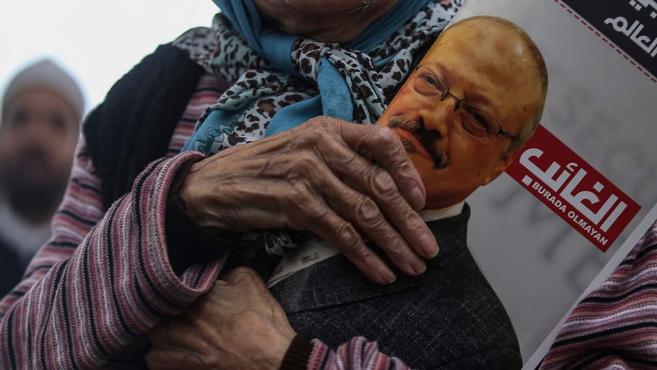 A woman holds a poster during the funeral prayers in absentia for Saudi writer Jamal Khashoggi.