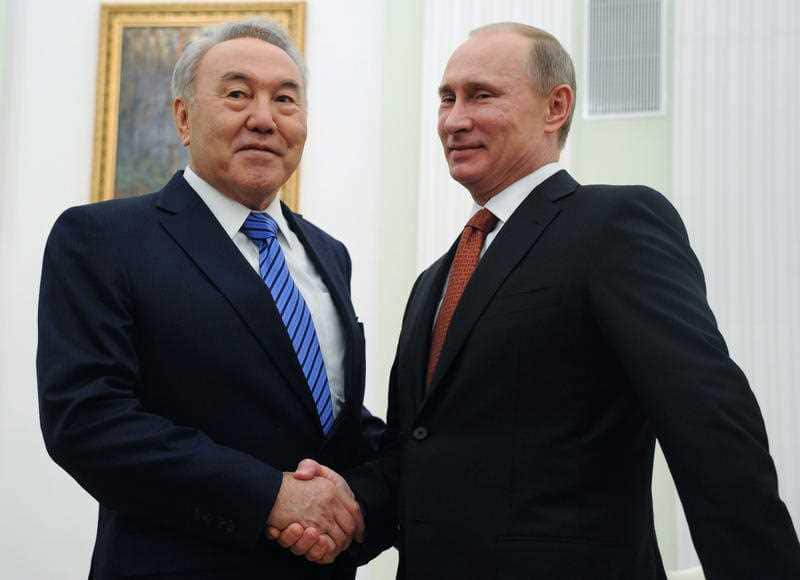 Russian President Vladimir Putin, right, and Kazakhstan's President Nursultan Nazarbayev shake hands in 2013.