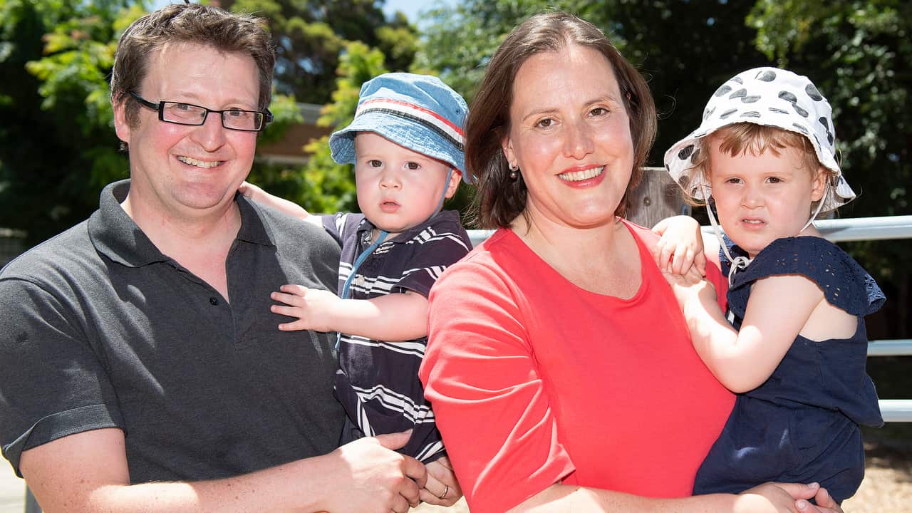 Jon Mant holding son Edward with wife Kelly O'Dwyer holding daughter Olivia. Ms O'Dwyer said she was tired of missing time with her children.