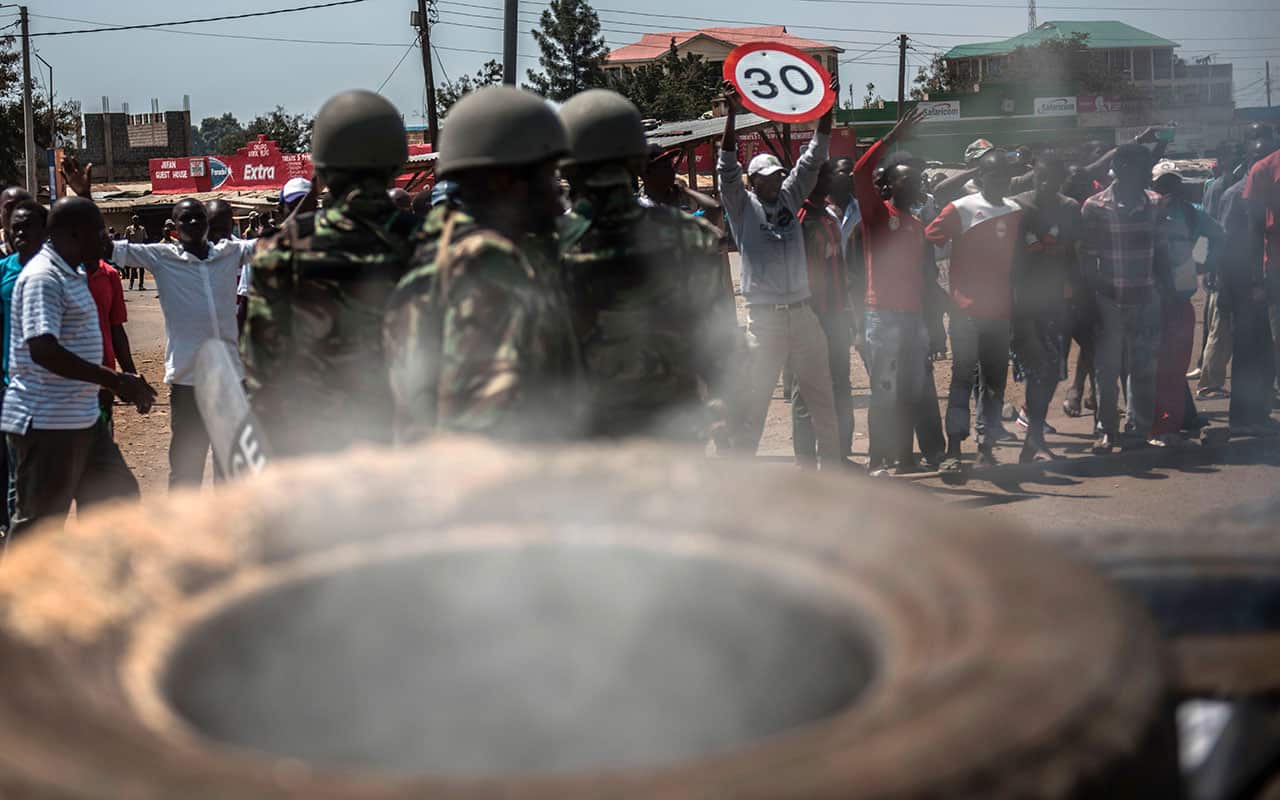 Kenyan police officers fire tear gas during clashes with supporters of the opposition leader Raila Odinga who protest at Kondele on August 9, 2017 in Kisumu, Kenya.