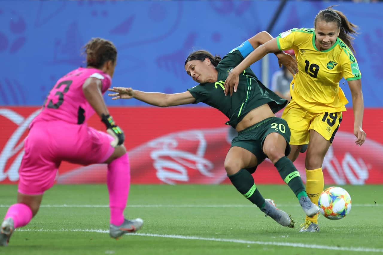 Australia's Sam Kerr, center, fights for the ball with Jamaica's Toriana Patterson, right, and Jamaica goalkeeper Nicole McClure.