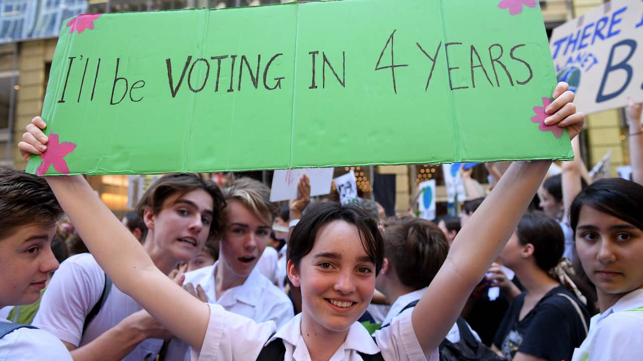 Emma Teffer of Burwood Girls High holds a placard as thousands of students rally demanding action on climate change, in Sydney.