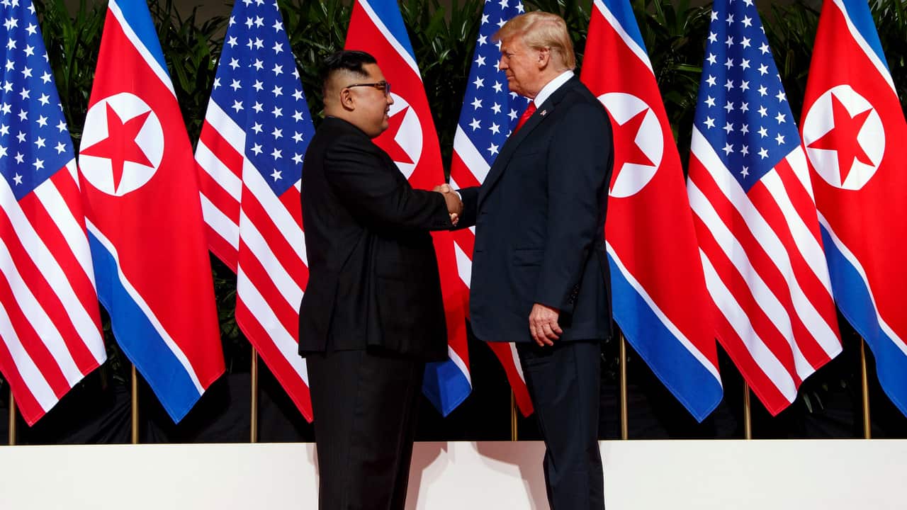 North Korean leader Kim Jong Un, left, and US President Donald Trump shake hands prior to their meeting on Sentosa Island in Singapore on 12/6/18.