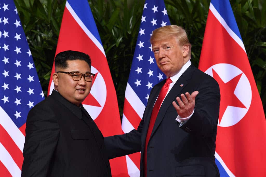 US President Donald Trump (R) gestures as he meets with North Korea's leader Kim Jong-un (L) at the start of their historic US-North Korea summit.