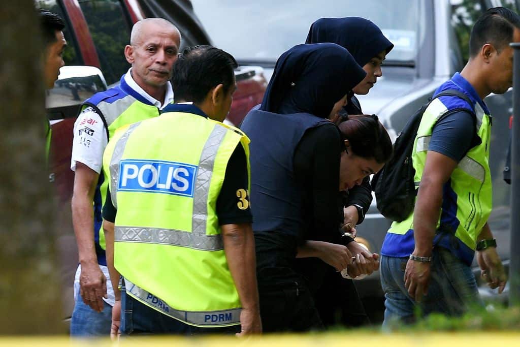 Indonesian national Siti Aisyah (R) is escorted by Malaysian police for a court appearance with Vietnamese national Doan Thi Huong.