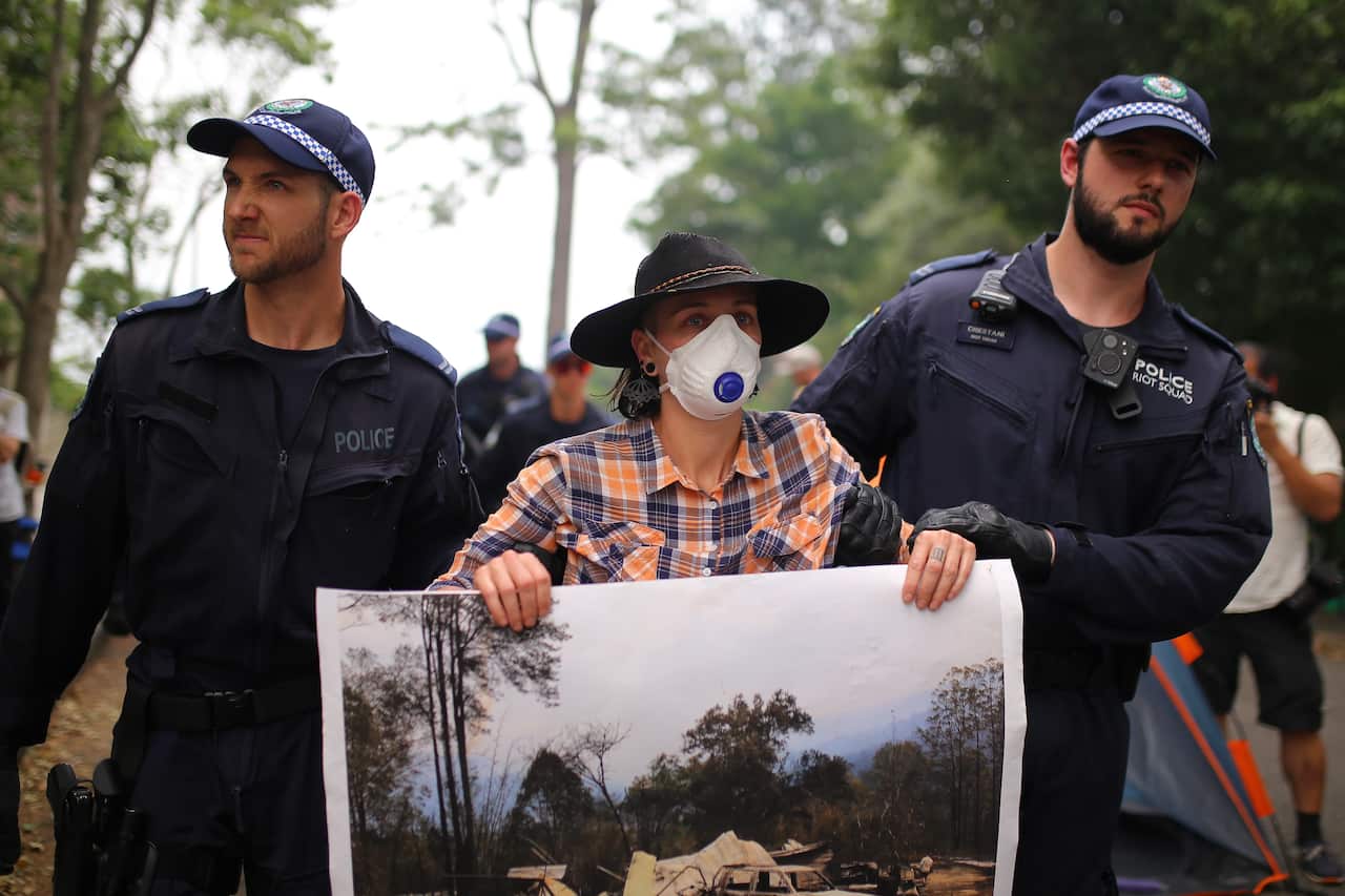 A protester is arrested outside of Kirribilli House as part of the sit in.