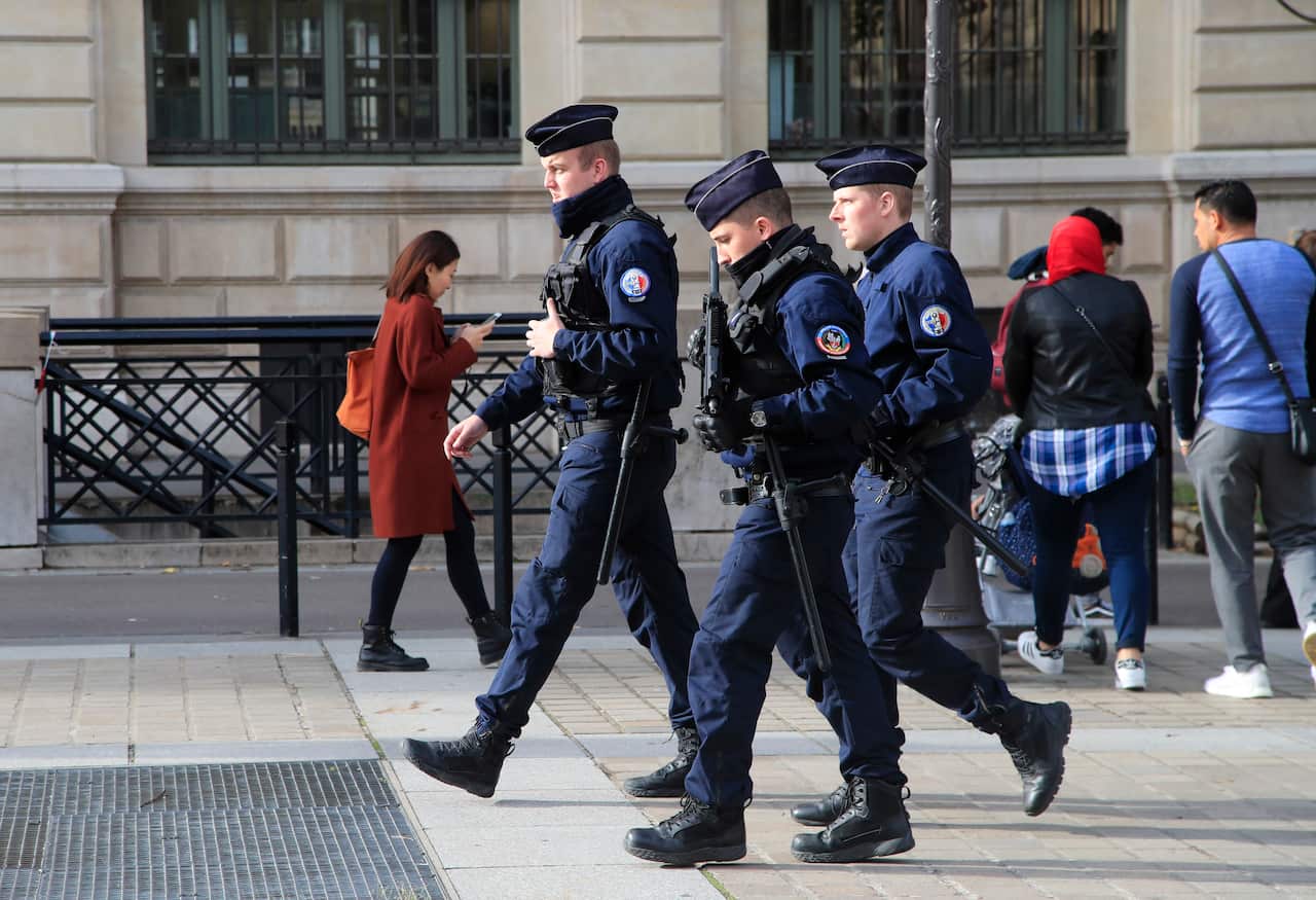 Police officers patrol outside the police headquarters in Paris, a day after the knife attack.