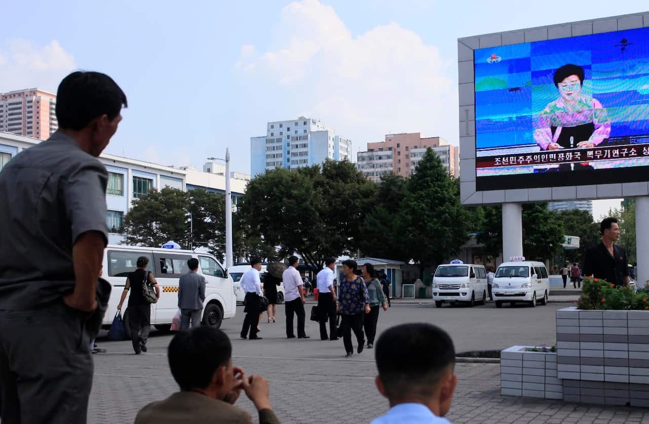 North Koreans watch a news report regarding a nuclear test on a large screen outside the Pyongyang Station in Pyongyang, North Korea (AAP)
