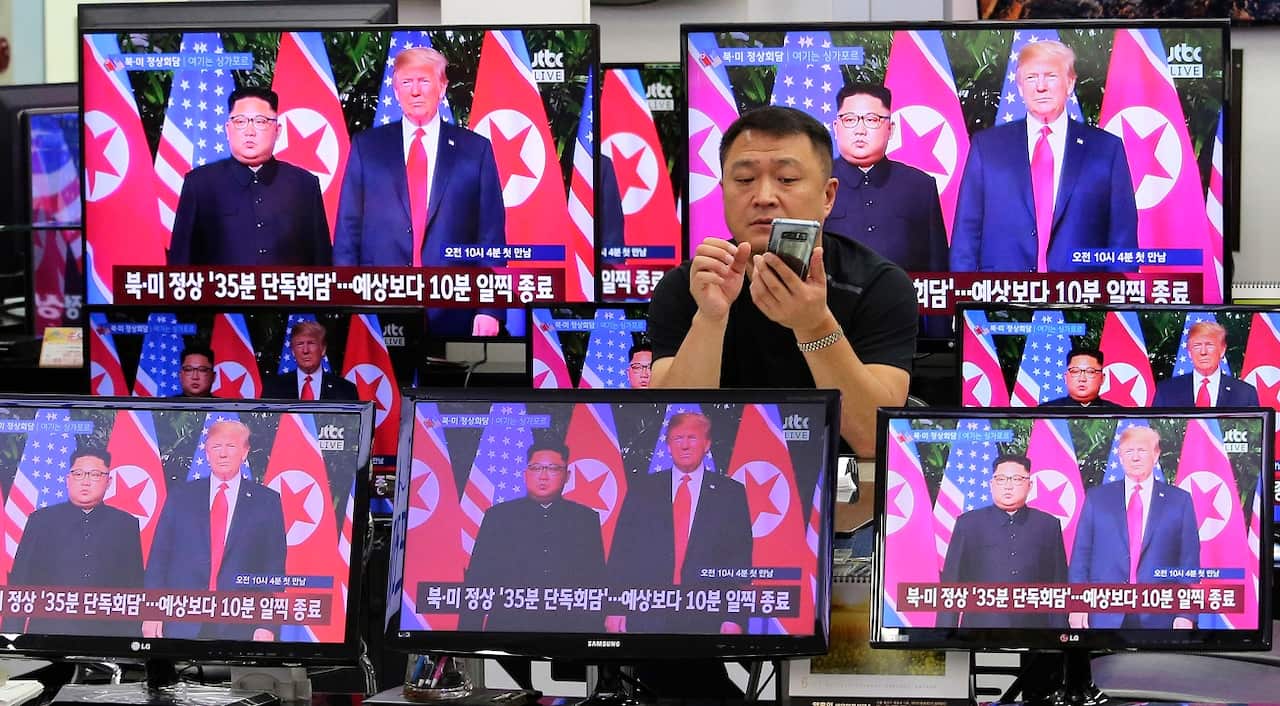 TV screens show the US President Donald Trump's, right, meeting with North Korean leader Kim Jong-un.