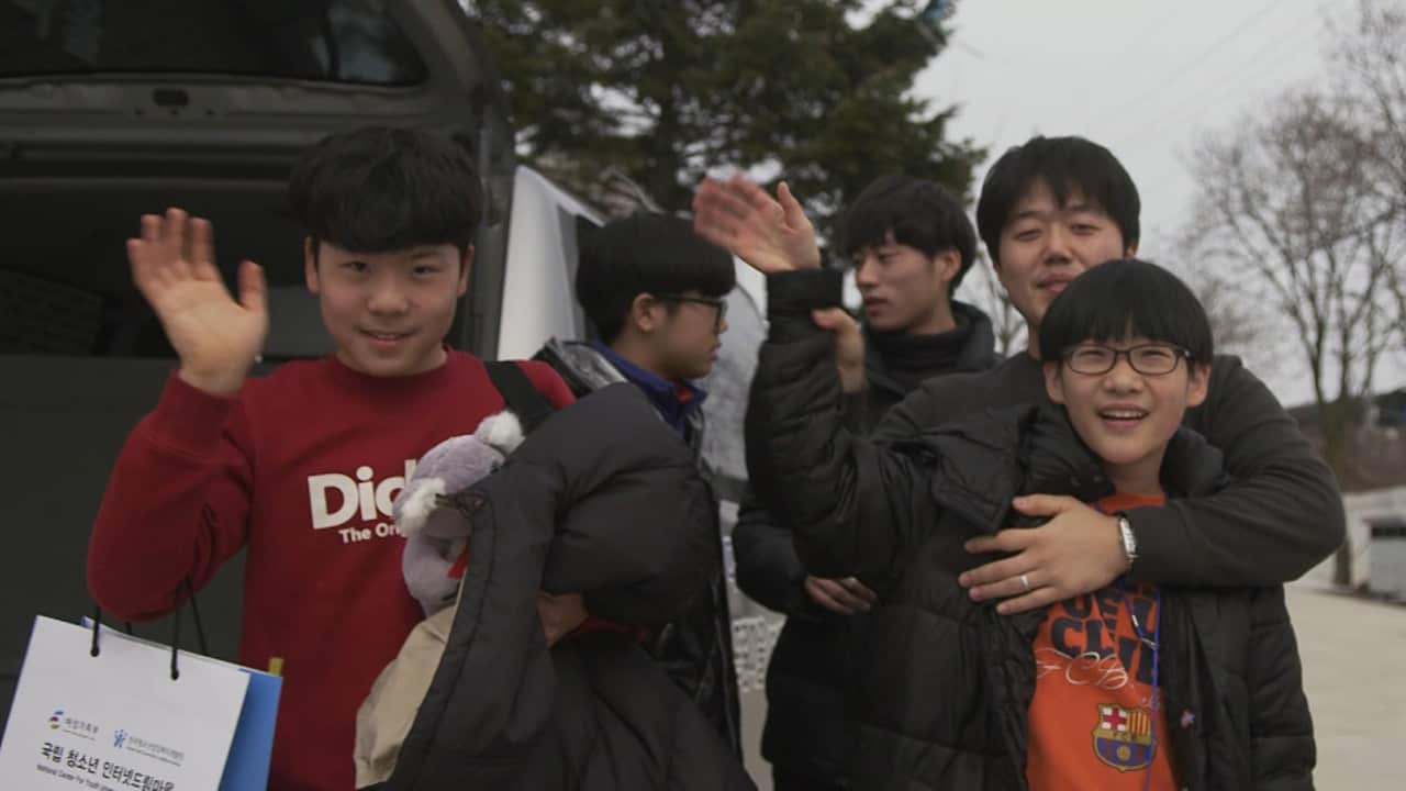 Chan Woo (left) and some of the other addicts wave goodbye, looking happier at the end of the rehab.