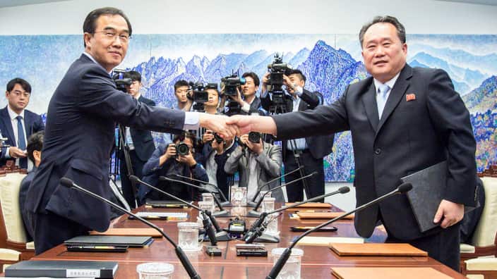 South Korean Unification Minister Cho Myoung-gyon (l) shakes hands with Ri Son-gwon from North Korea's Committee for the Peaceful Reunification of the country.