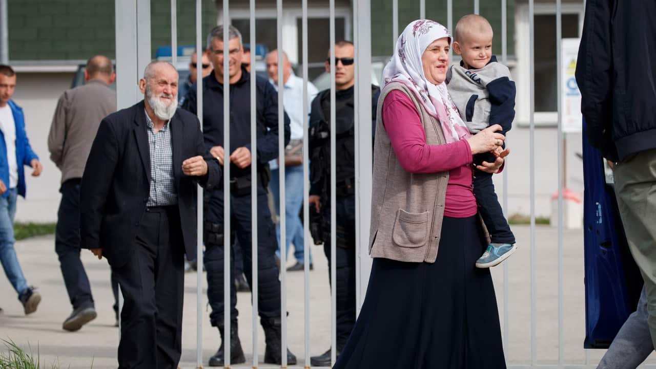 An elderly woman holds her grandson, both parents of whom were killed in Syria, after being released from the foreign detention center in Vranidoll, Kosovo.