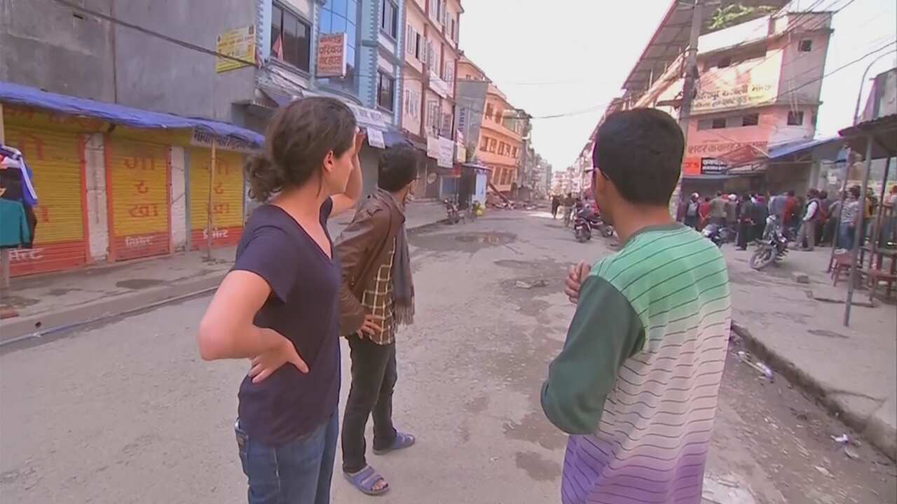 Meggie and Krishna had to run as a building near his collapsed. Another building can be seen leaning as they look back down the street.