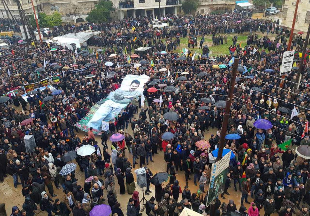 People's Protection Units or YPG protestors waving a giant poster of jailed PKK leader Abdullah Ocalan