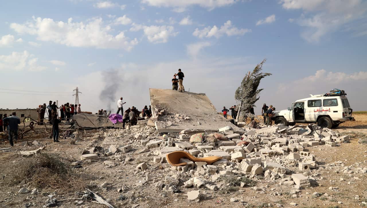 American volunteers search the rubble of a house for the bodies of victims at Ras al-Ain town, northeastern Syria.