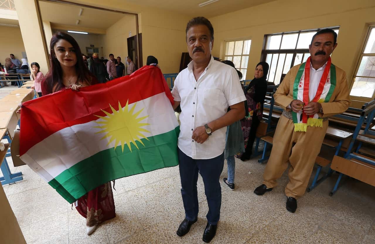 Iraqi Kurd voters hold a Kurdish flag at polling station during Kurdistan independence referendum in Erbil, Kurdistan region in northern Iraq